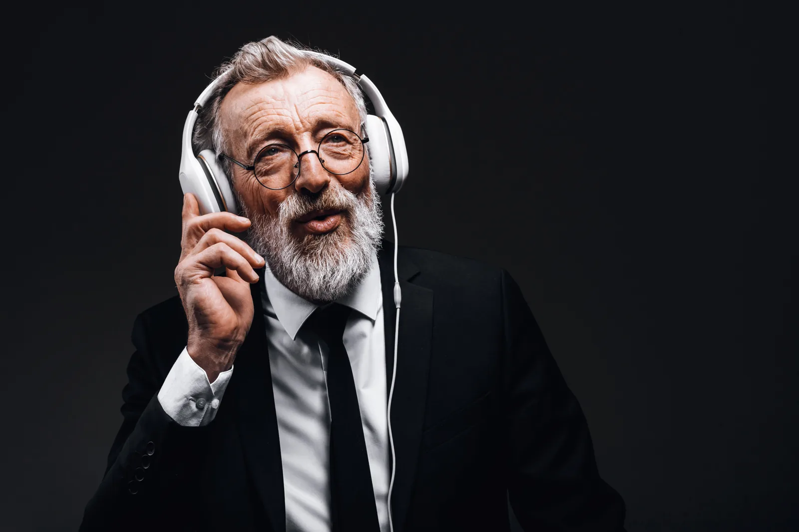 A man in a suit listening through headphones